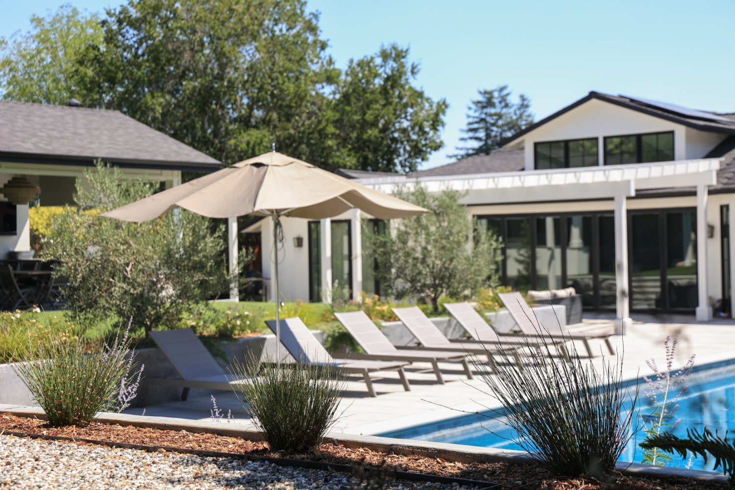 Poolside patio featuring Techo-Bloc pavers and outdoor entertainment spaces by K&D Landscaping