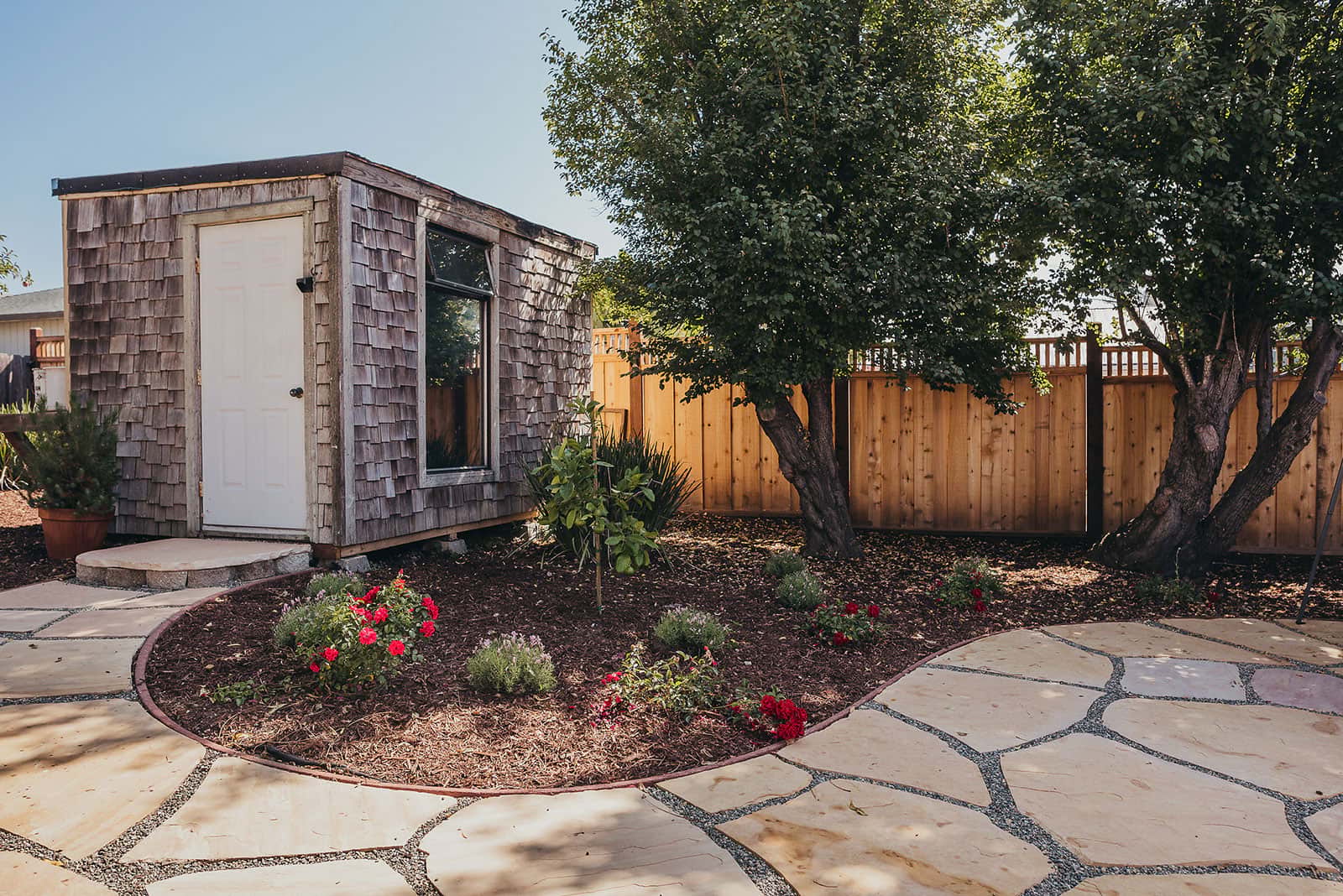 Residential shade garden with mature trees, stepping stone pathway, native plantings, and modern landscape design by K&D Landscaping