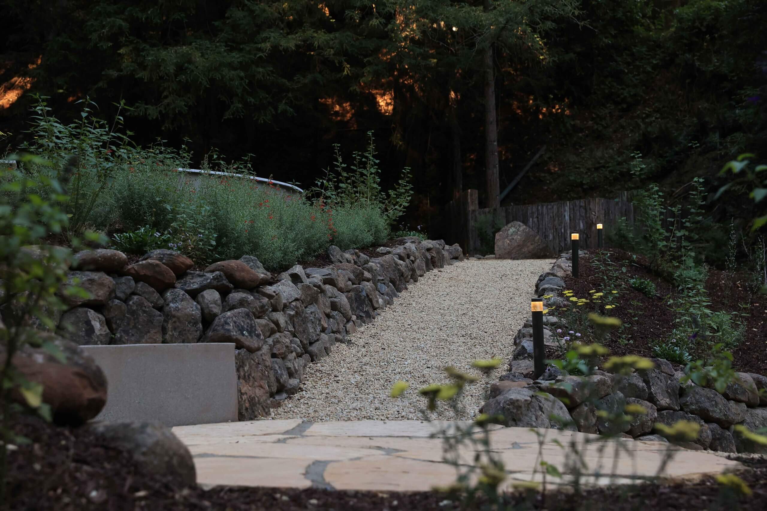 Retaining walls and boulder features integrated into a woodland landscape by K&D Landscaping