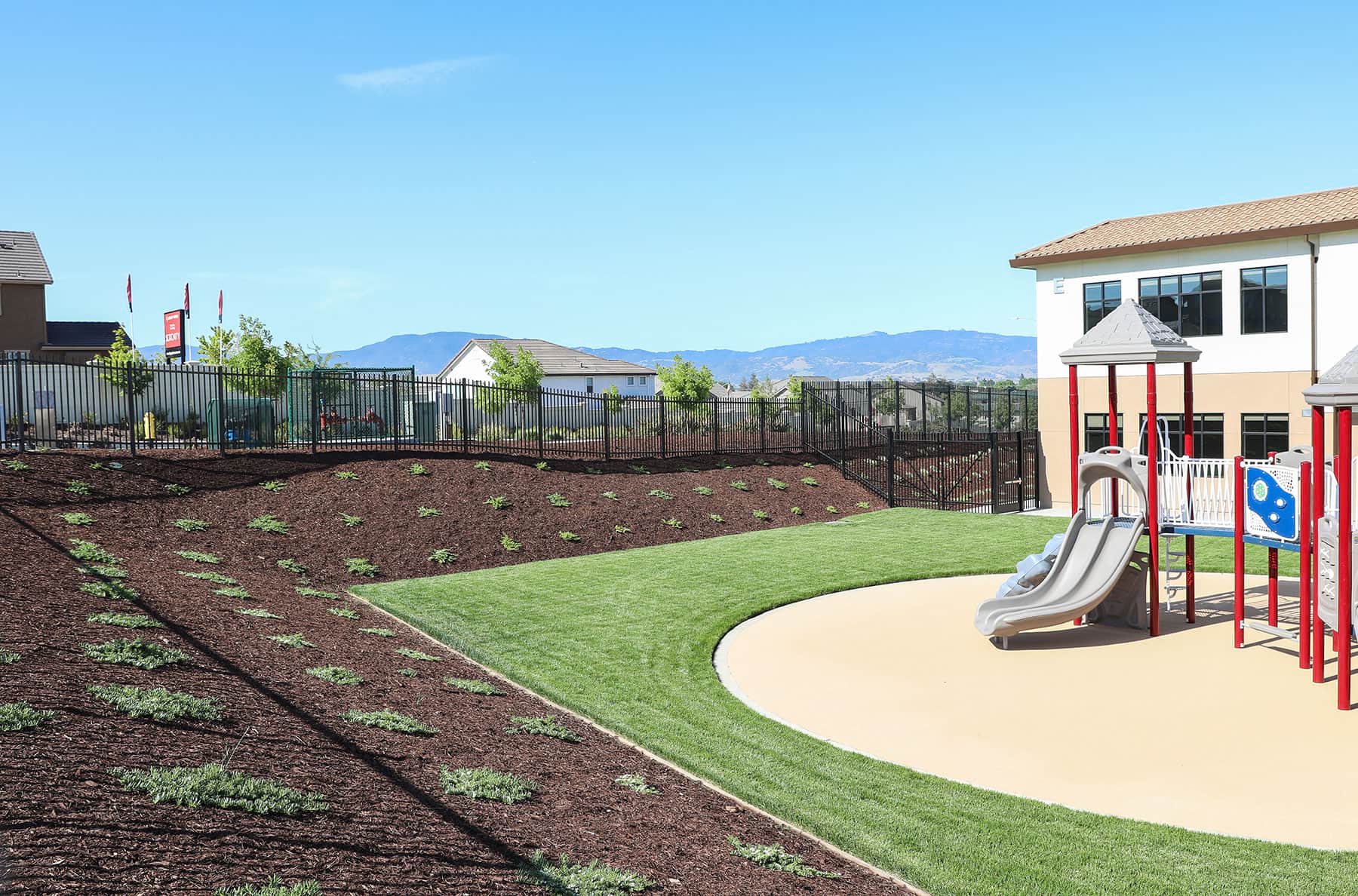 School landscape featuring mulch beds and pedestrian walkways by K&D Landscaping