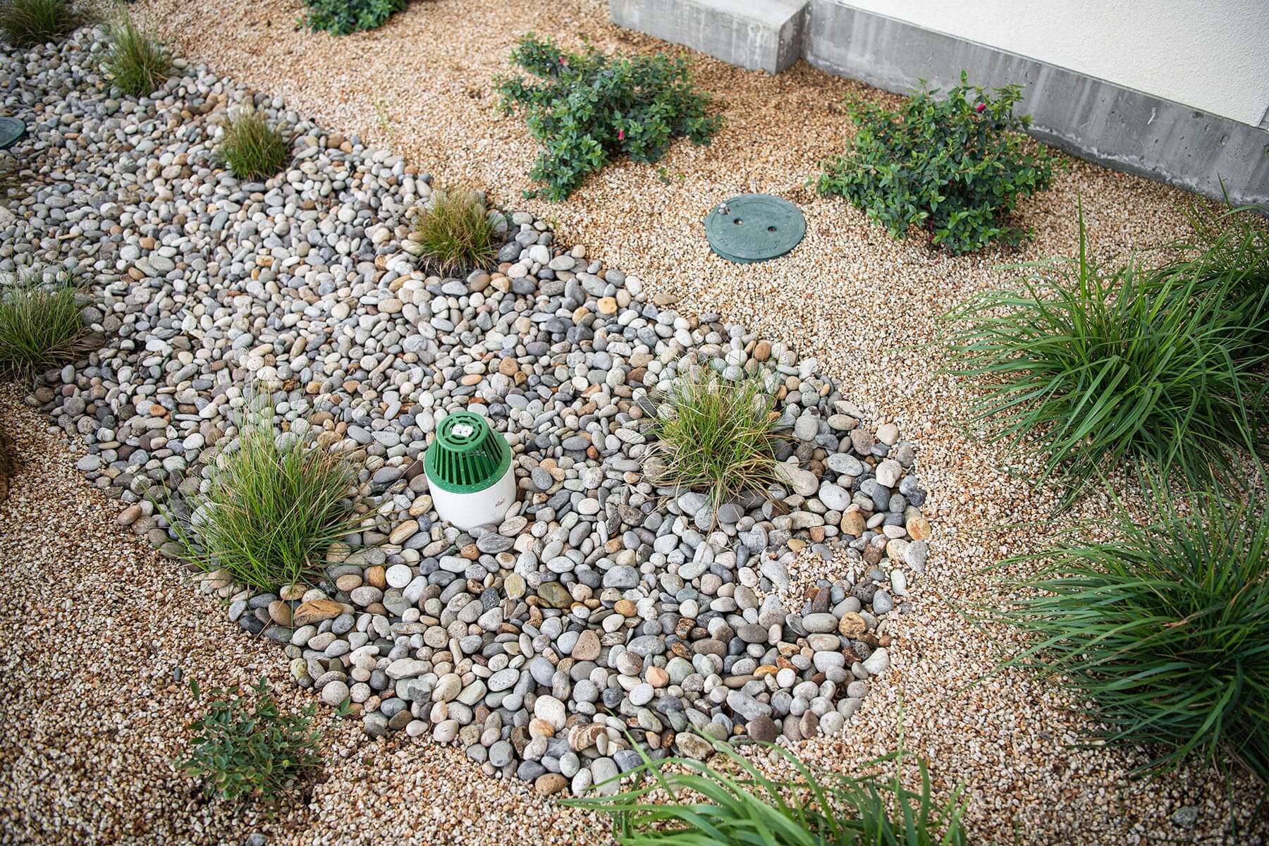 Waterfront pedestrian area with shoreline planting, drainage stone, and commercial landscape construction by K&D Landscaping
